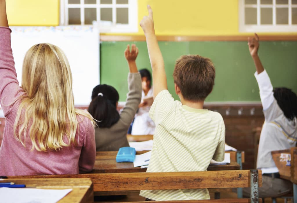children raising their hand in the classroom - from iStockPhoto