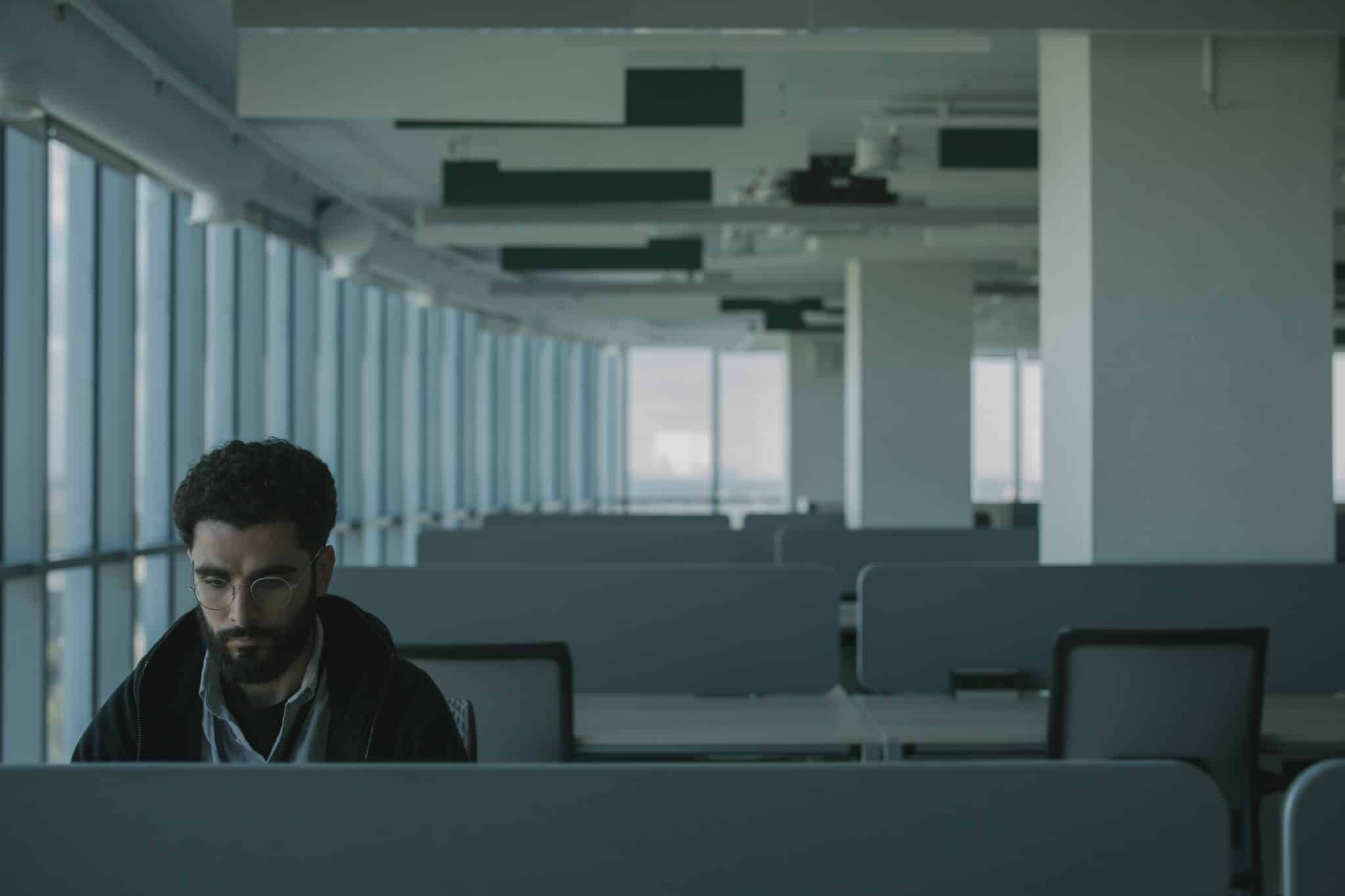 A man sitting alone in an office - photo by cottonbro studio