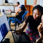 woman and man sitting in front of monitor doing code review, Photo by Desola Lanre-Ologun on unsplash